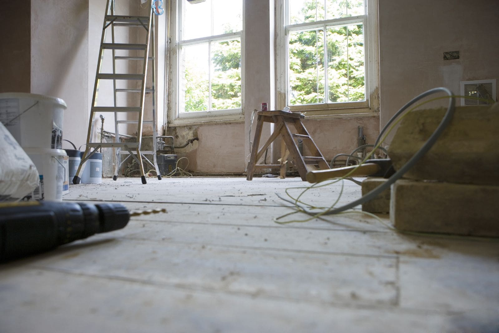 Interior de chalet en obra, con el suelo de madera y las instalaciones a la vista