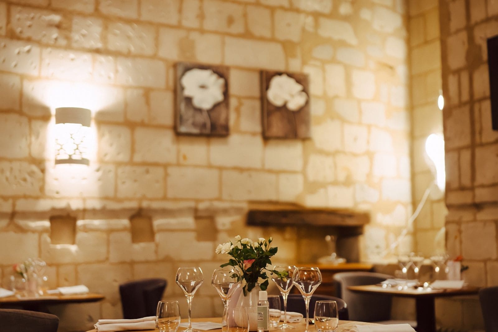 Comedor de restaurante con pared de piedra vista e iluminación cálida