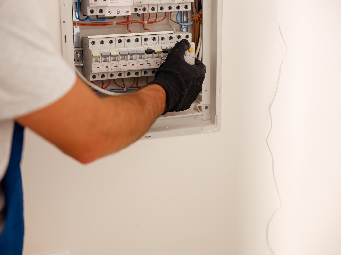 Electricista trabajando en el cuadro electrico empotrado de una vivienda
