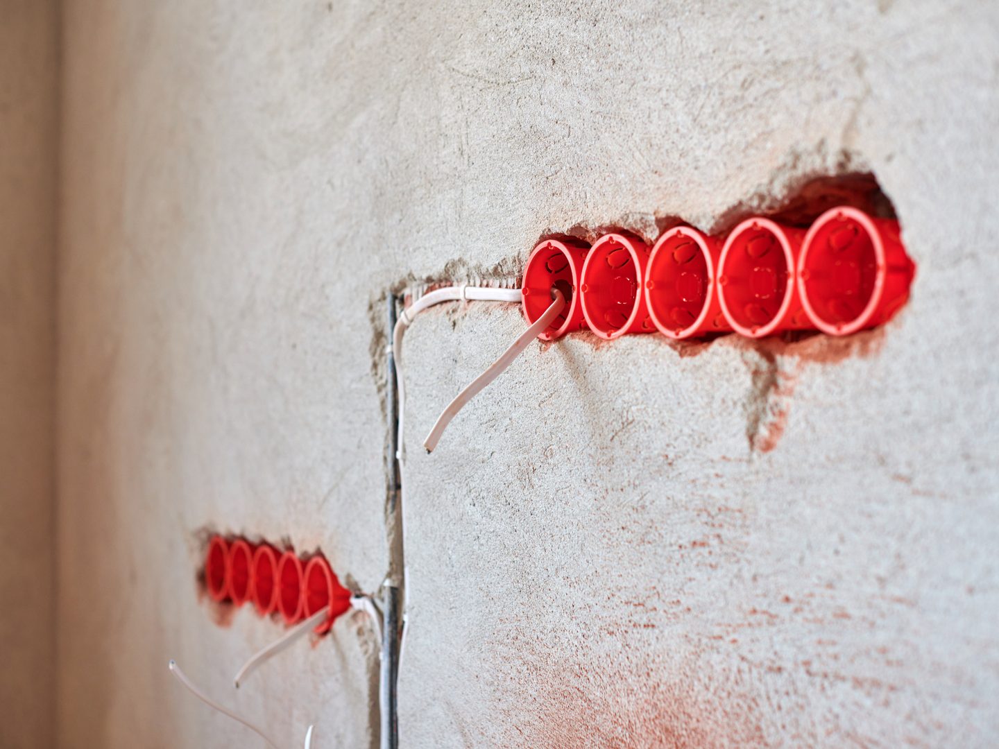 Cajas de mecanismos empotradas en la roza de una pared con el tubo corrugado y el cable pasado