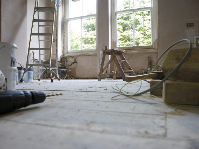 Habitación de un piso en obra con escaleras, herramientas y cableado nuevo en una reforma integral
