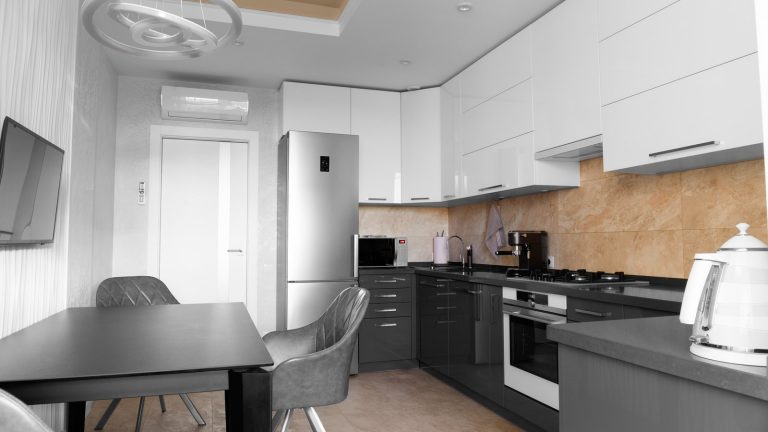 Cocina pequeña reformada en Zaragoza con distribución en L, muebles hasta el techo y una mesa office