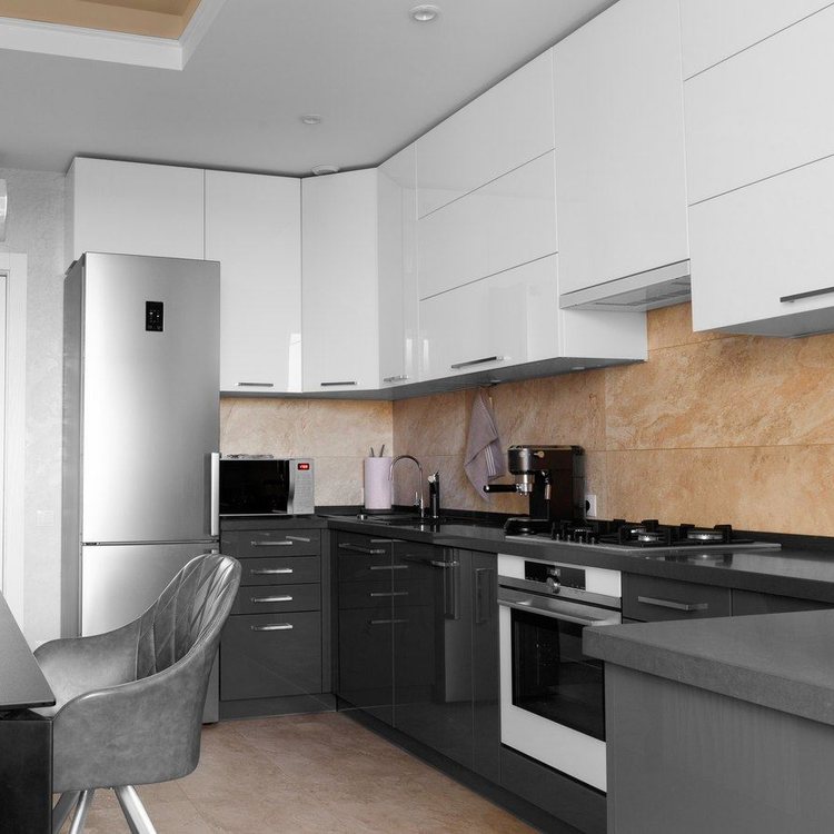 Rincón de cocina con frigorífico de acero, horno integrado y frente de azulejo beige