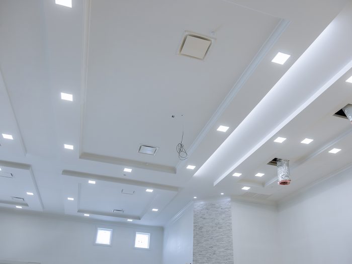 Techo de un local con luminarias empotradas, rejillas de ventilación y la climatización a medio montar