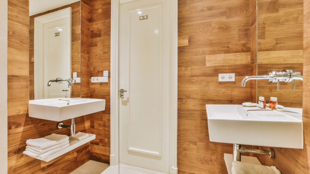 Baño estrecho reformado con porcelánico imitación madera y lavabos suspendidos