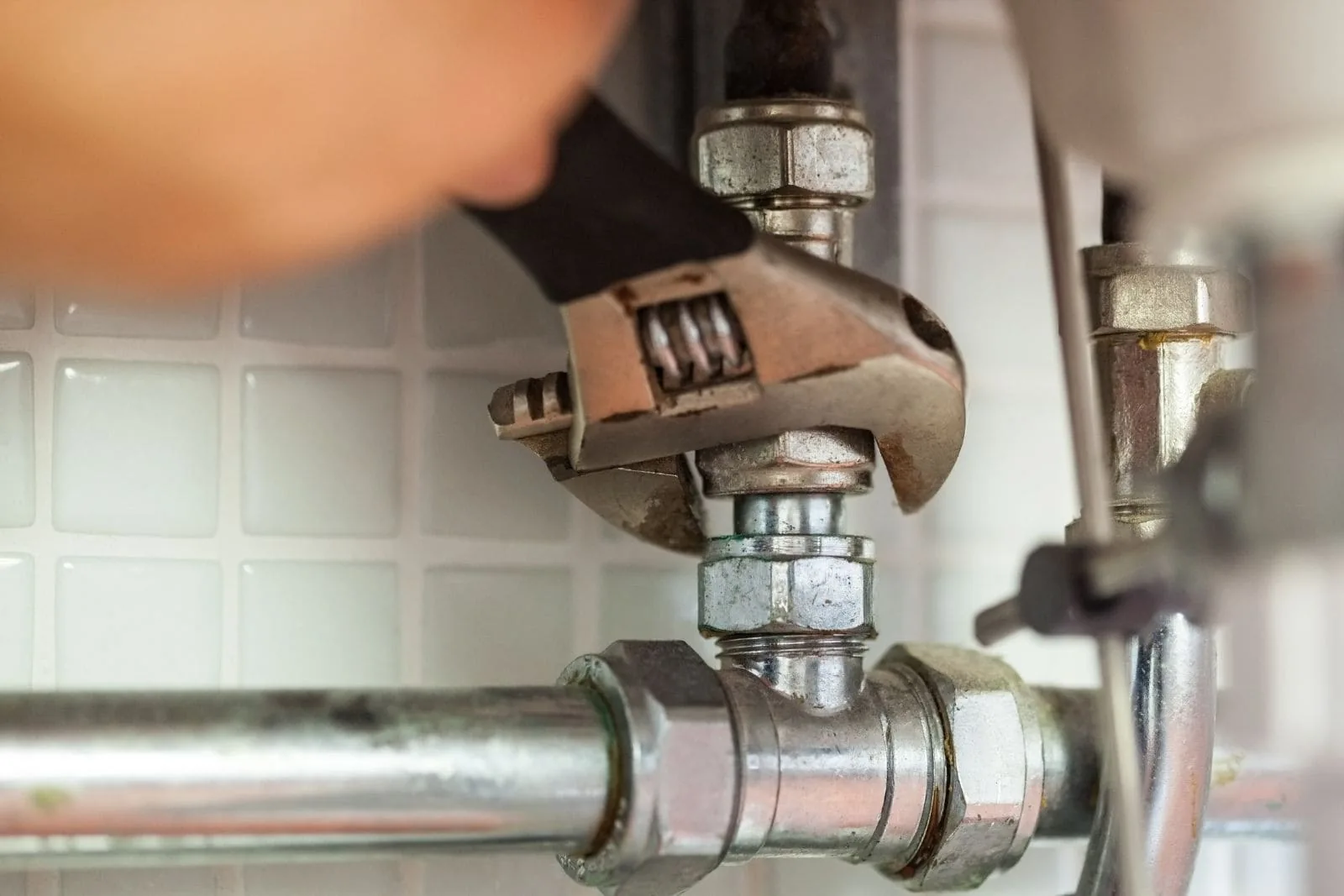 Llave inglesa apretando una llave de escuadra en una instalación de agua antigua, fontanero edificios antiguos Zaragoza
