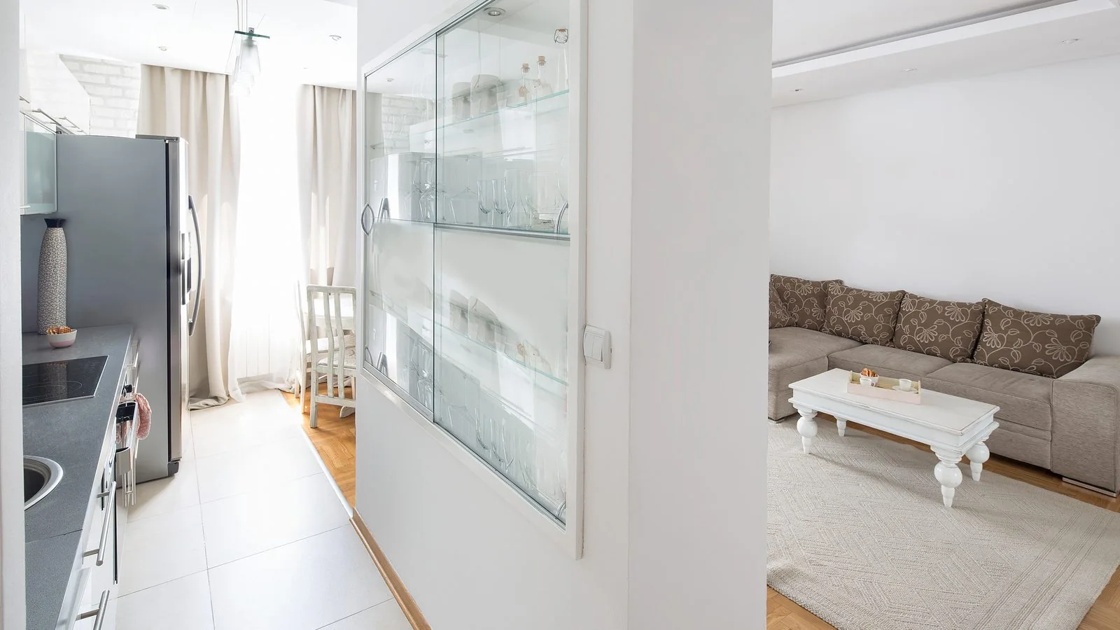 Salón y cocina de un piso reformado separados por una vitrina de cristal, merece la pena reformar para alquilar Zaragoza