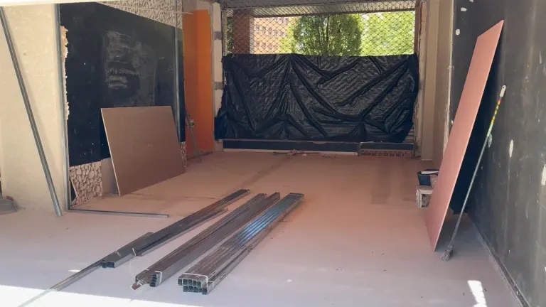Local en obra con la perfilería de pladur en el suelo y las placas apoyadas en la pared, reforma de locales en Zaragoza
