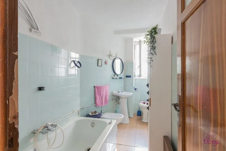Baño antiguo con bañera, azulejo verde agua y lavabo de pie, reforma integral antes y después Zaragoza