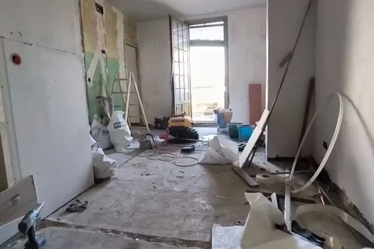 Salón en obra antes de la reforma, con las paredes abiertas y escombro en el suelo, reforma piso 60 metros Zaragoza